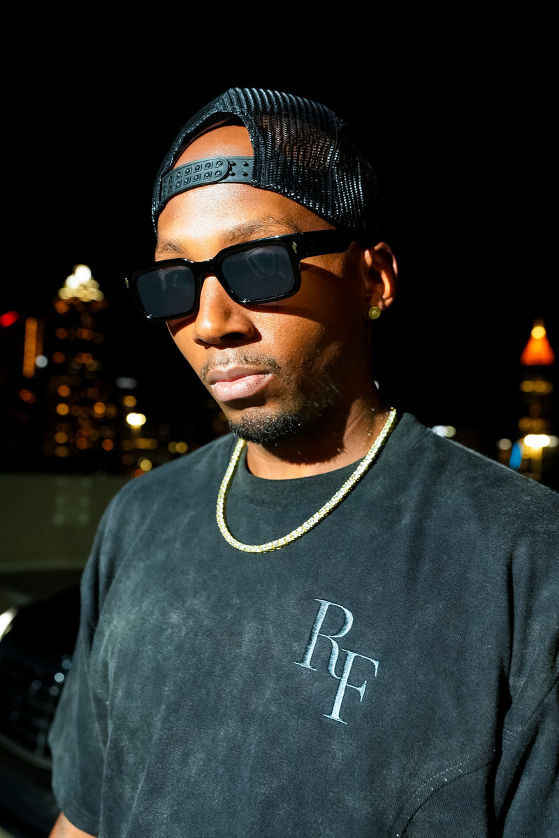 Silent Construct Signature Tee — front close-up of the tonal RF chest embroidery on the washed-black wash, worn.